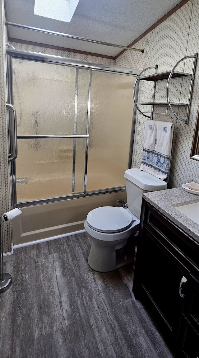 full bathroom featuring vanity, bath / shower combo with glass door, a skylight, a textured ceiling, and wood-type flooring