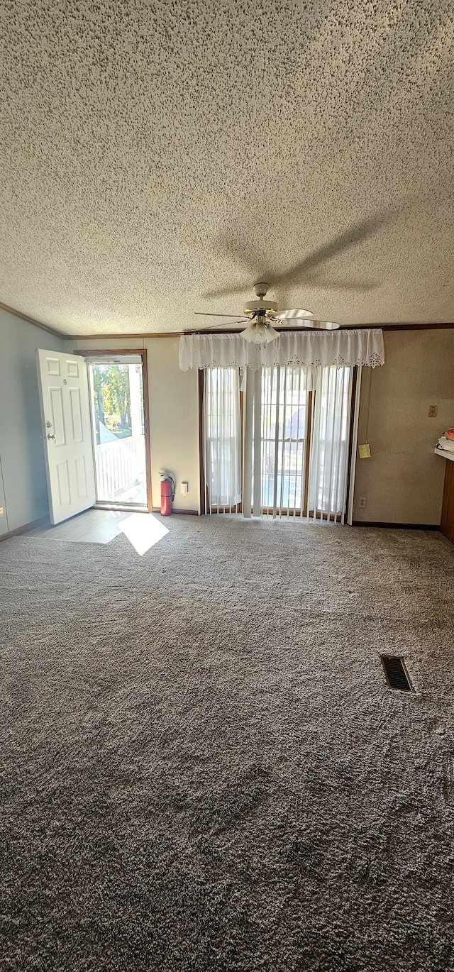 carpeted spare room featuring ceiling fan and a textured ceiling