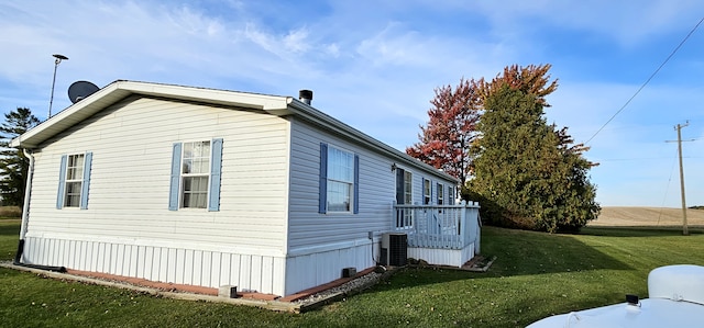 view of property exterior featuring central AC unit and a lawn