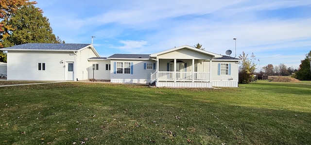 back of property with a porch and a yard