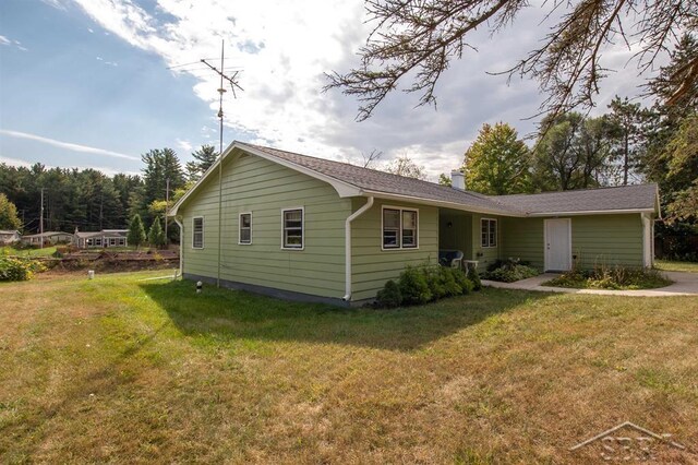 4029 Cobblestone Ct, Beaverton, MI 48612 - rear view of house with a lawn and a chimney