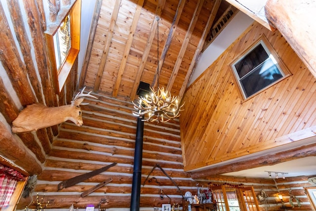 interior details with beam ceiling, wood ceiling, rustic walls, and a chandelier