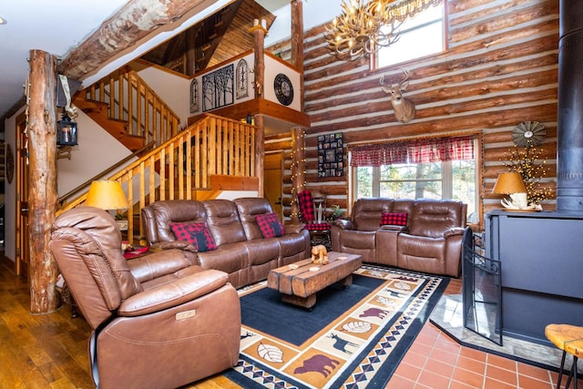 tiled living room with rustic walls, stairway, a high ceiling, and a wood stove