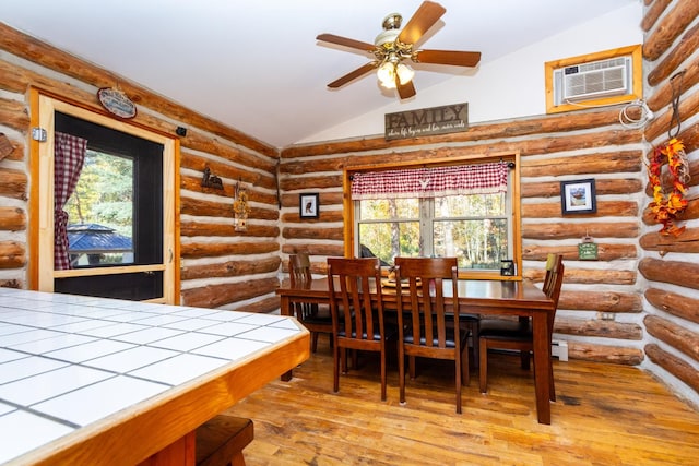 dining room with a wall mounted air conditioner, light hardwood / wood-style floors, ceiling fan, and lofted ceiling