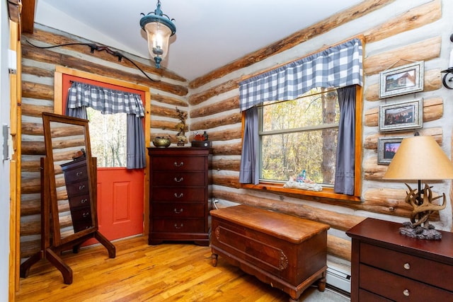 living area with light hardwood / wood-style floors, lofted ceiling, and rustic walls