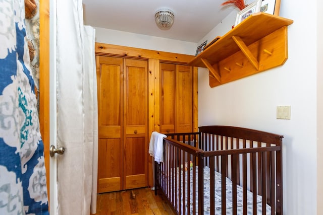 bedroom with hardwood / wood-style floors and a crib