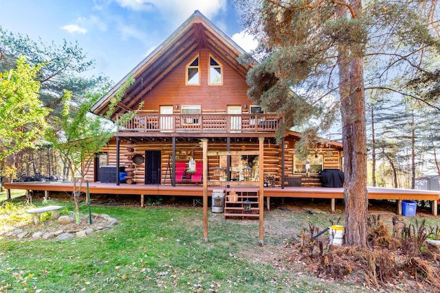 rear view of property featuring a lawn and a wooden deck