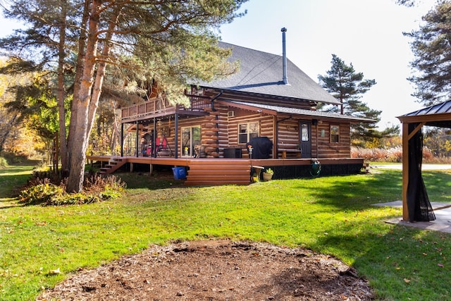 rear view of house with a deck and a lawn