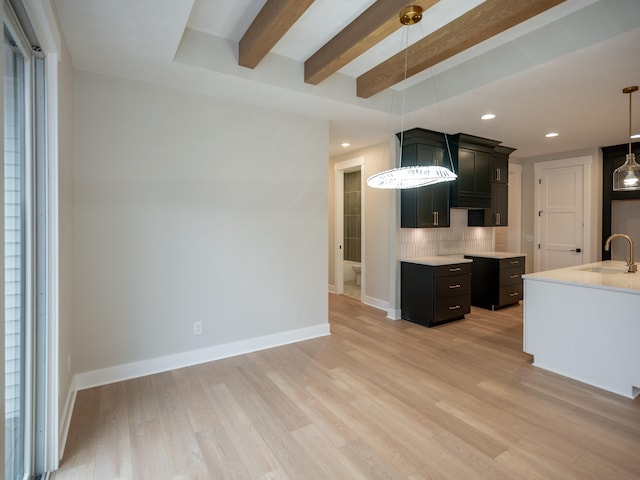 kitchen with pendant lighting, light hardwood / wood-style floors, and tasteful backsplash