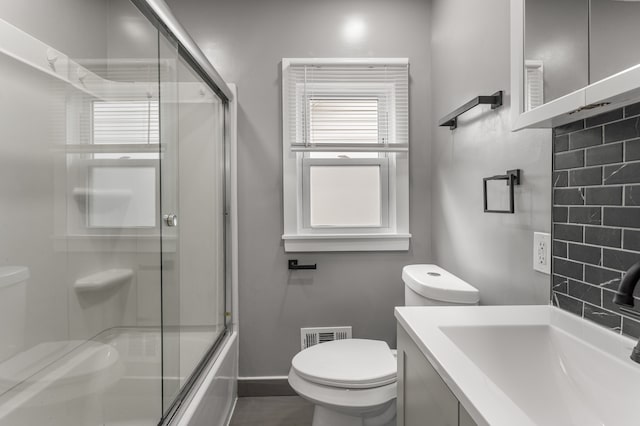 full bathroom featuring shower / bath combination with glass door, vanity, and toilet