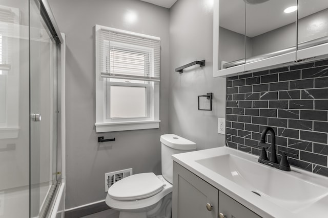 full bathroom featuring vanity, backsplash, toilet, and enclosed tub / shower combo