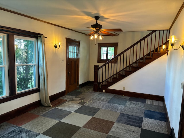 foyer with ceiling fan, ornamental molding, and a wealth of natural light