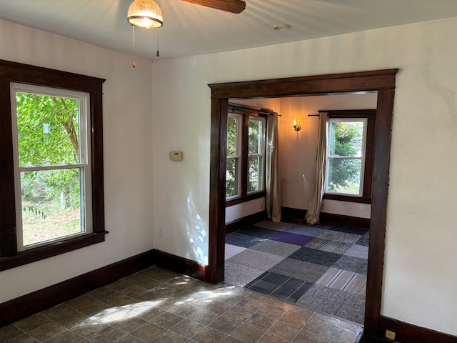 unfurnished room featuring a wealth of natural light and ceiling fan