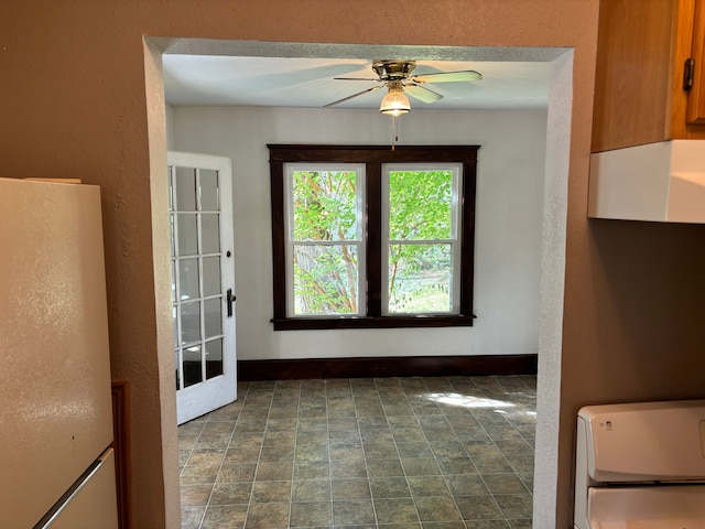 unfurnished dining area featuring ceiling fan and french doors