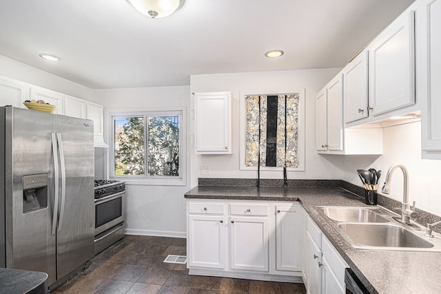 kitchen featuring stainless steel appliances, white cabinetry, and sink