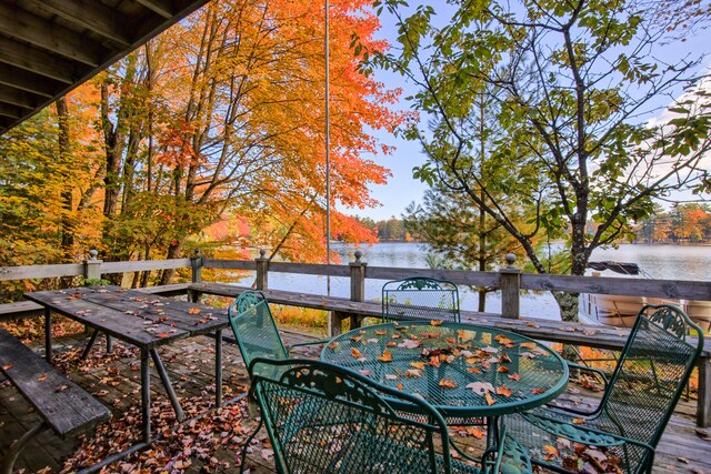 8918 W School Section Lake Dr, Mecosta, MI 49332 - wooden terrace featuring outdoor dining space and a water view
