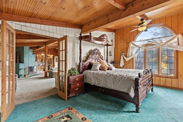 8918 W School Section Lake Dr, Mecosta, MI 49332 - bedroom with carpet flooring, wood walls, wooden ceiling with exposed beams, french doors, and a fireplace