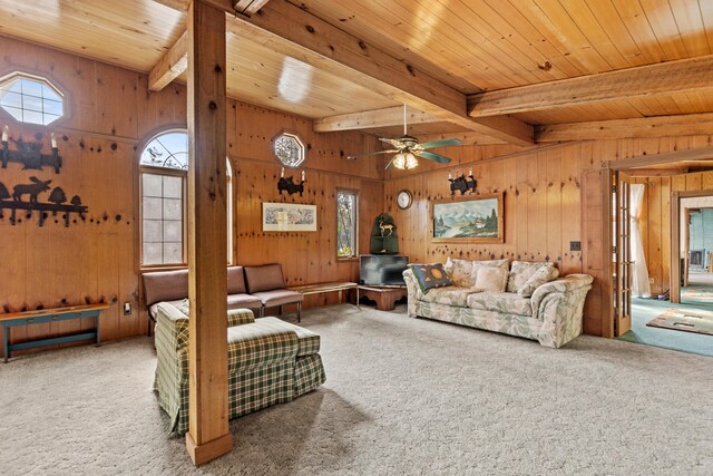 8918 W School Section Lake Dr, Mecosta, MI 49332 - living area featuring carpet flooring, wood walls, a ceiling fan, and wooden ceiling with exposed beams
