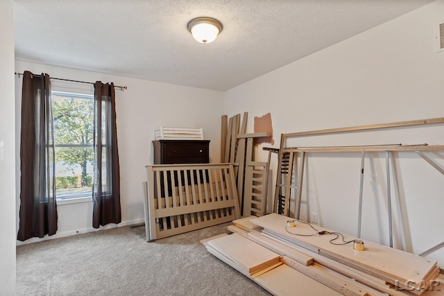 bedroom featuring light colored carpet and a textured ceiling