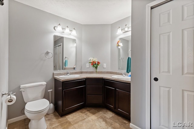 bathroom with vanity, a textured ceiling, and toilet