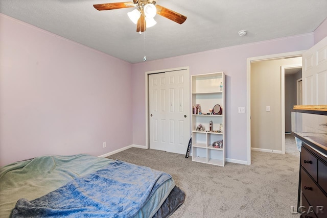 carpeted bedroom featuring ceiling fan and a closet