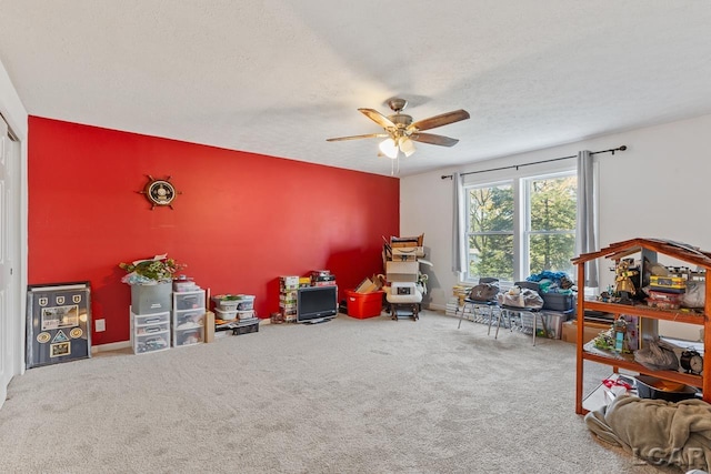 game room with carpet flooring, a textured ceiling, and ceiling fan