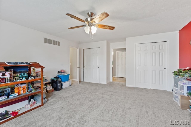 interior space with light carpet, ceiling fan, and a textured ceiling