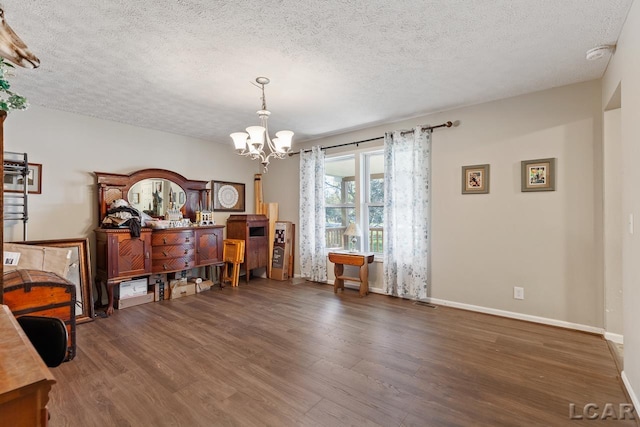 interior space with dark hardwood / wood-style flooring, a chandelier, and a textured ceiling