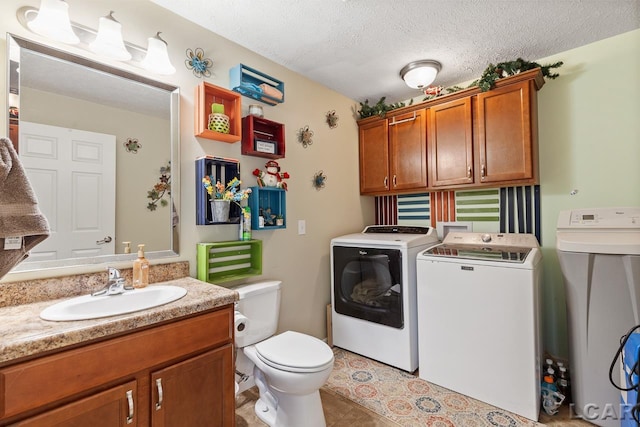 clothes washing area featuring washer and dryer, light tile patterned flooring, sink, and a textured ceiling