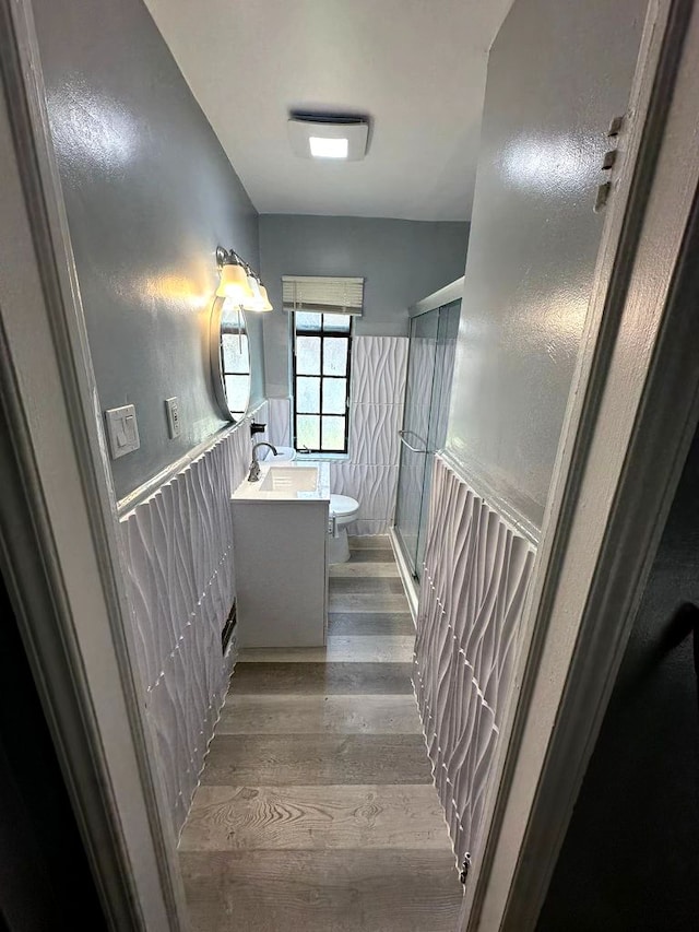 staircase with hardwood / wood-style floors and sink