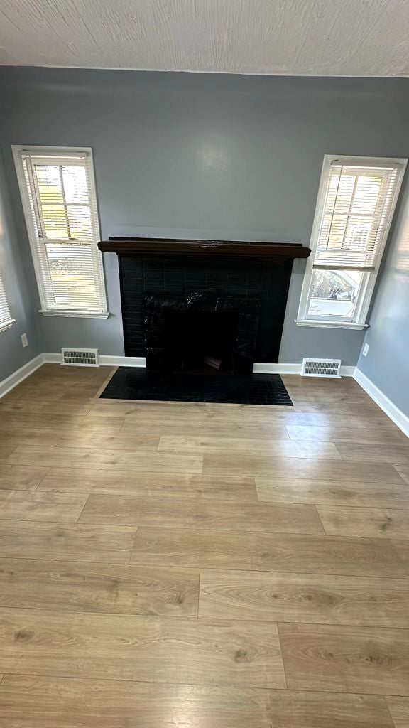 unfurnished living room featuring a healthy amount of sunlight and light hardwood / wood-style flooring