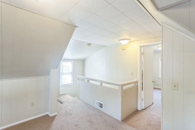 bonus room featuring light carpet and vaulted ceiling