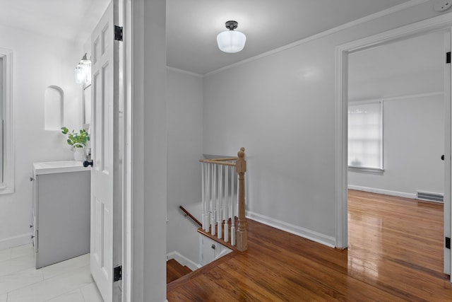 hallway with sink, light hardwood / wood-style floors, and ornamental molding