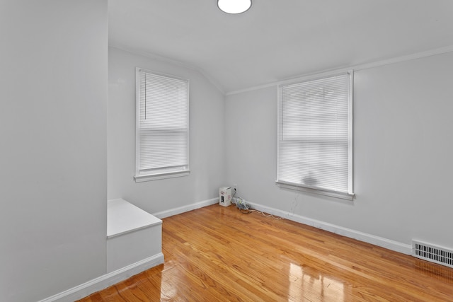 unfurnished room with lofted ceiling and hardwood / wood-style flooring