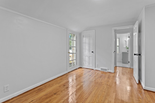 spare room with light hardwood / wood-style floors, lofted ceiling, and ornamental molding