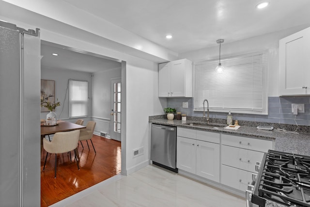 kitchen featuring pendant lighting, white cabinetry, sink, and stainless steel appliances