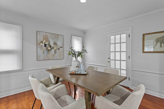 dining space with hardwood / wood-style floors and ornamental molding