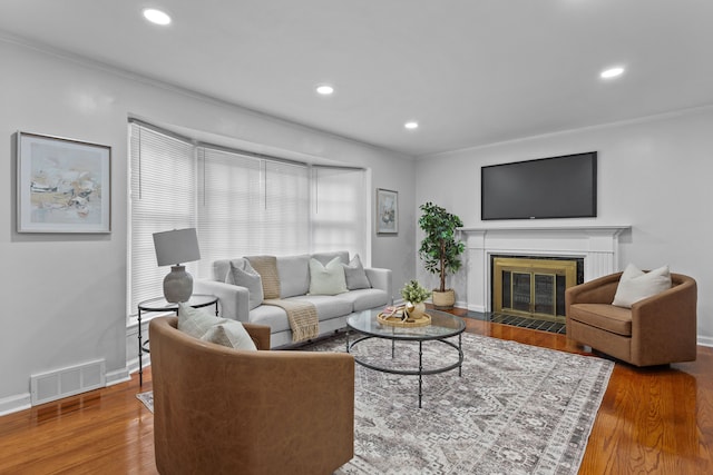 living room featuring wood-type flooring and crown molding