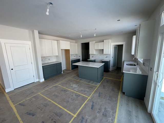 kitchen with a center island, decorative backsplash, and white cabinets