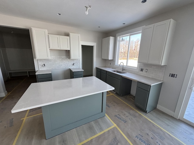 kitchen with gray cabinets, white cabinetry, a center island, and sink