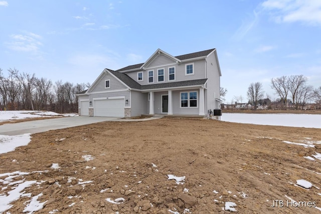 view of front of property with a garage and a water view