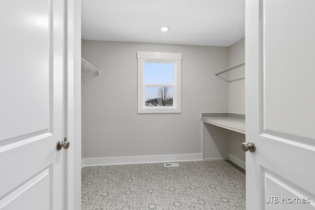 spacious closet featuring light colored carpet