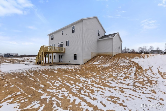 snow covered house featuring a deck