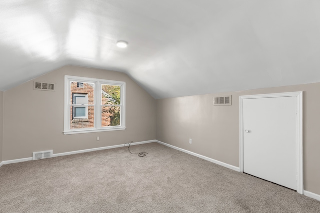 additional living space featuring lofted ceiling and carpet floors