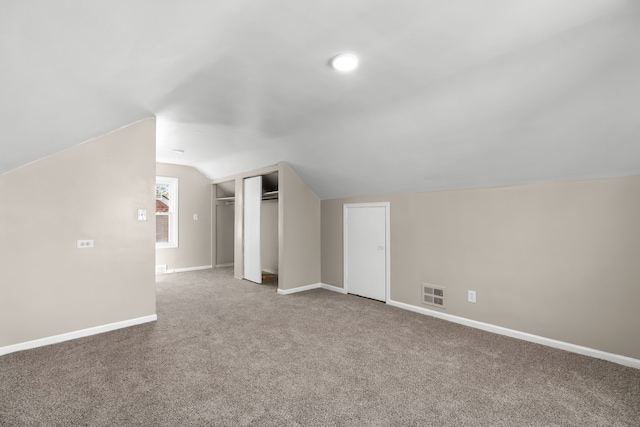 additional living space with carpet flooring and lofted ceiling