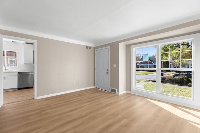 spare room with sink and light hardwood / wood-style floors