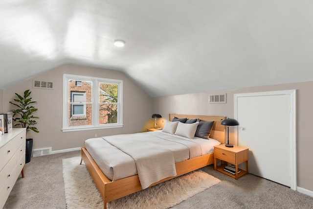 bedroom with carpet floors and vaulted ceiling