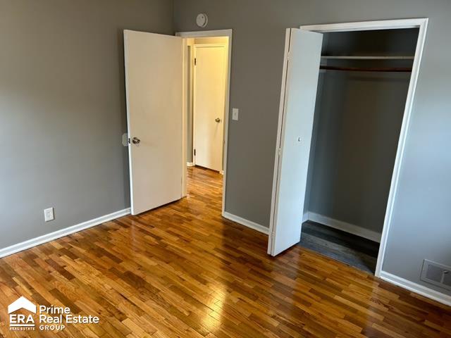 unfurnished bedroom with hardwood / wood-style flooring and a closet