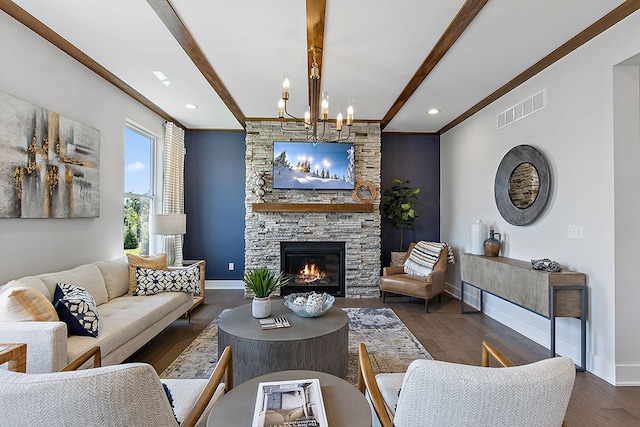 living room featuring beamed ceiling, a stone fireplace, dark wood-type flooring, and an inviting chandelier