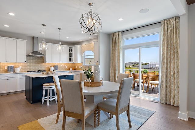 dining room with light hardwood / wood-style floors, an inviting chandelier, and sink